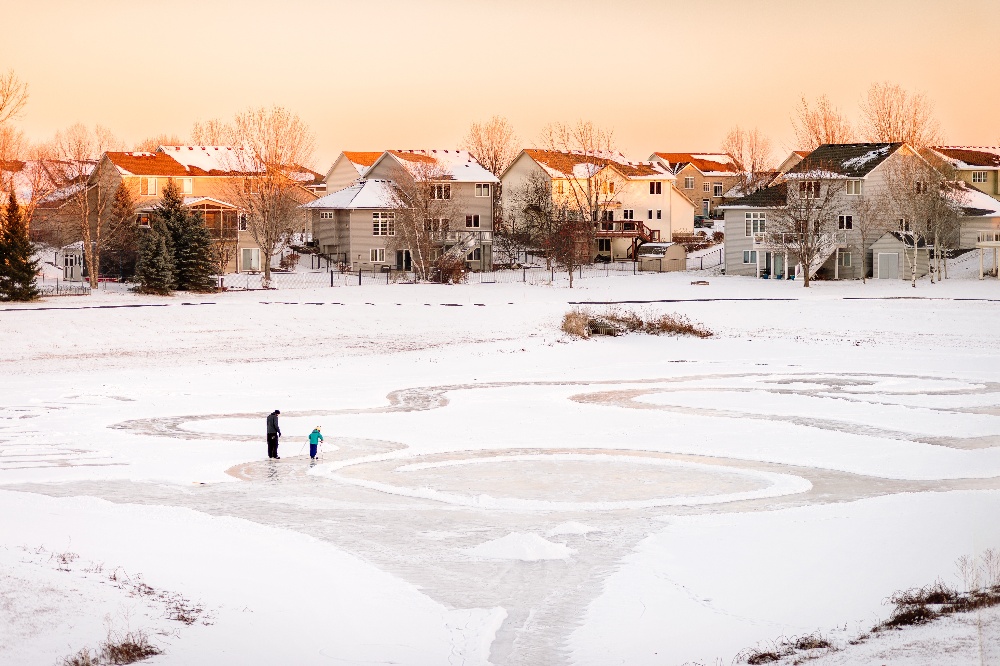 Family playing on the snow behind their home